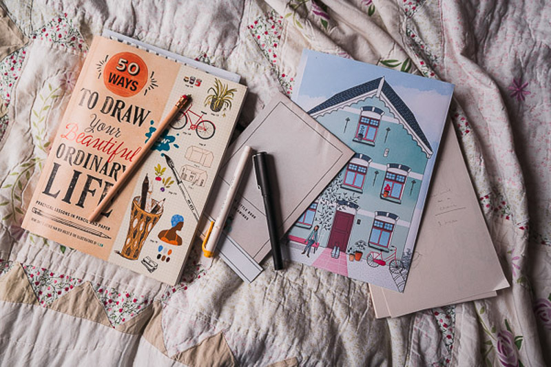 50 Ways to Draw Your Beautiful Ordinary Life drawing textbook with a few scattered pencils