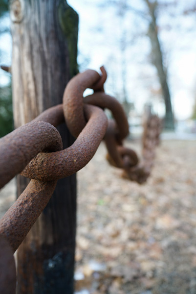 Rusty chains link together to form a fence.
