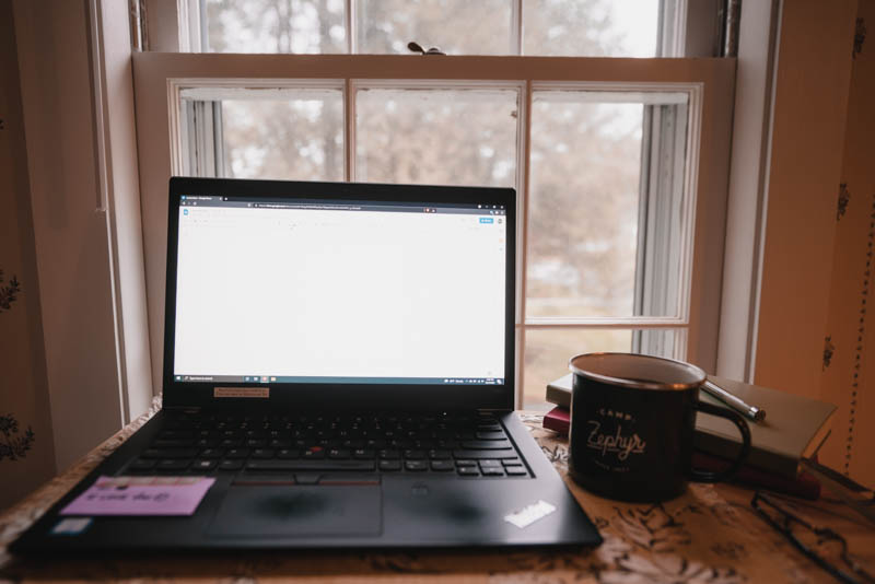 A view of my desk, with a view outside, preparing to write for the next two hours with my laptop and tea in hand.